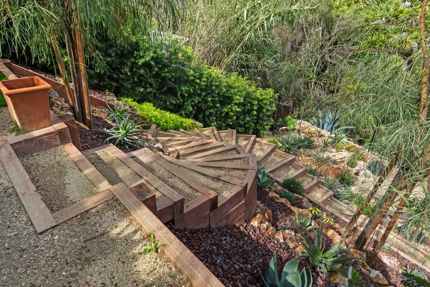 Curved timber and gravel steps built into a hillside terrace