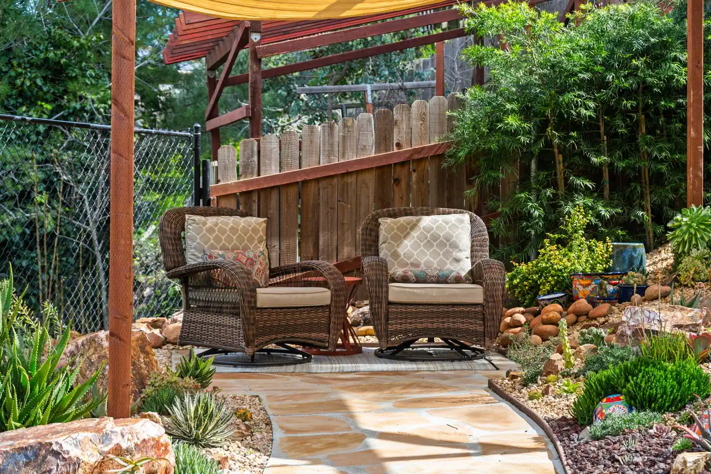 Outdoor seating area under a pergola on a flagstone terrace