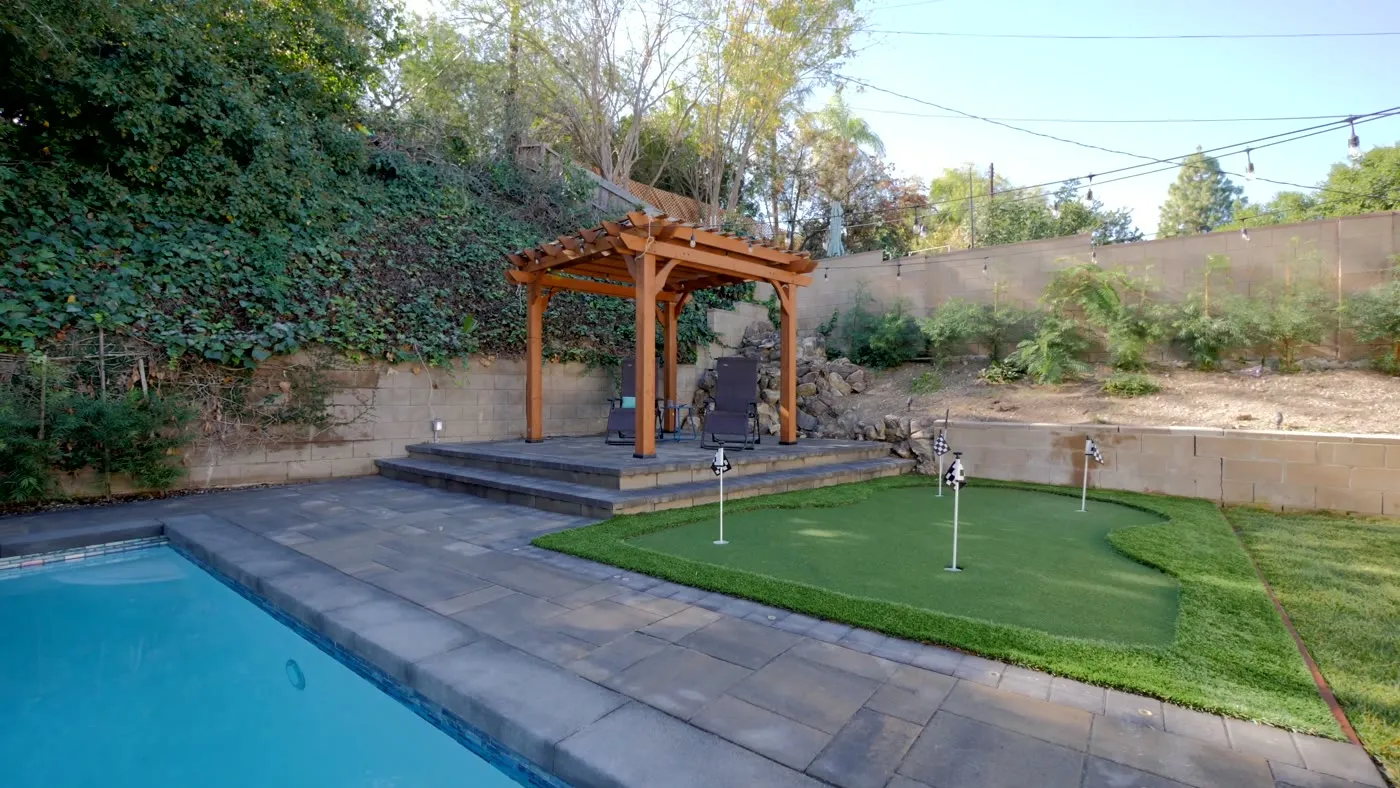Pergola terrace and putting green beside a Woodland Hills pool
