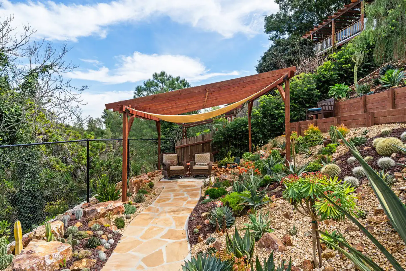 Shade structure and flagstone path on a hillside terrace with a valley view