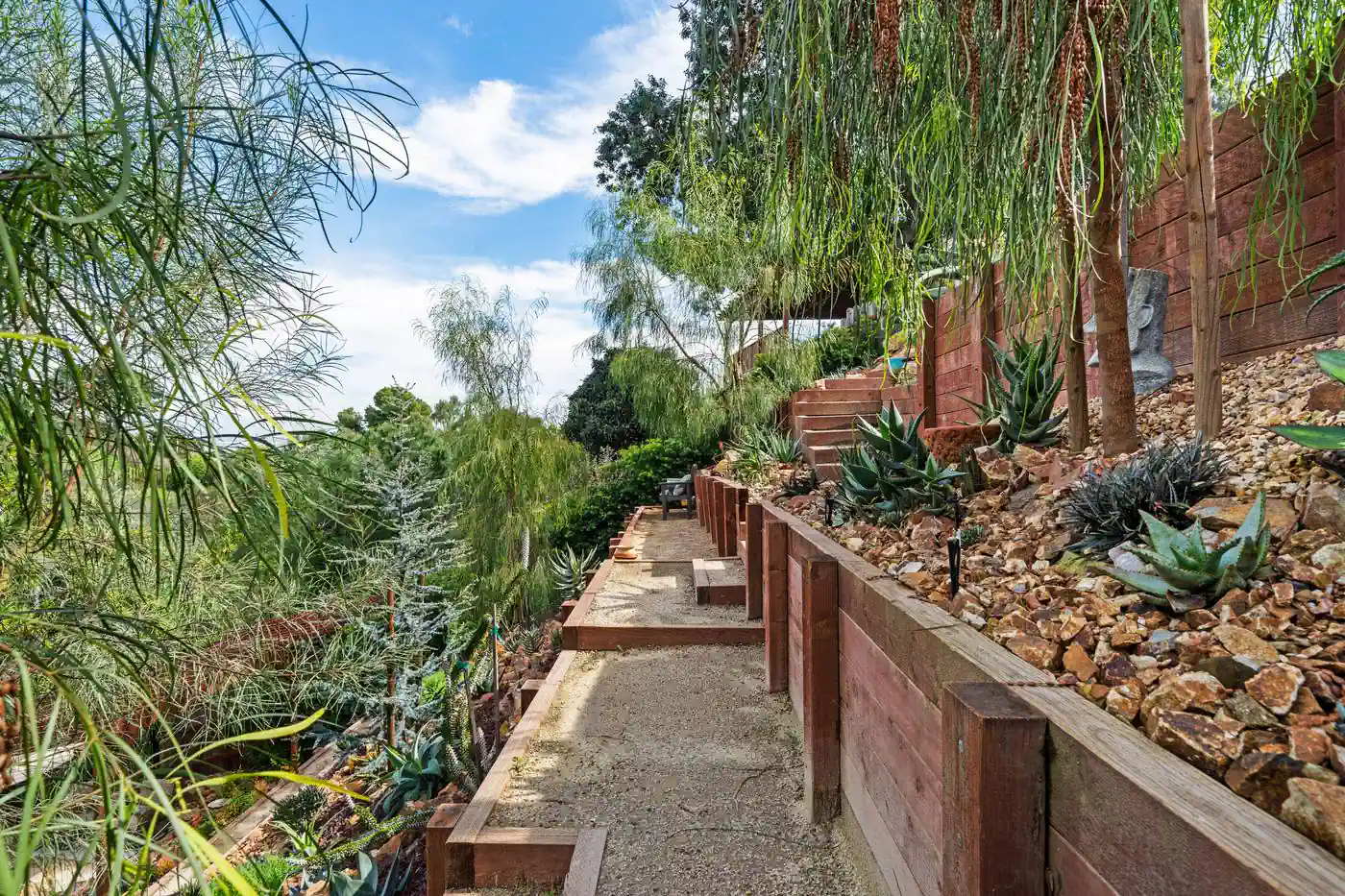 Decomposed granite walkway running alongside a timber retaining wall